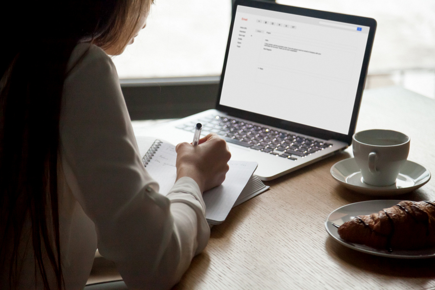 woman-making-notes-reading-email-letter-laptop-cafe.jpg