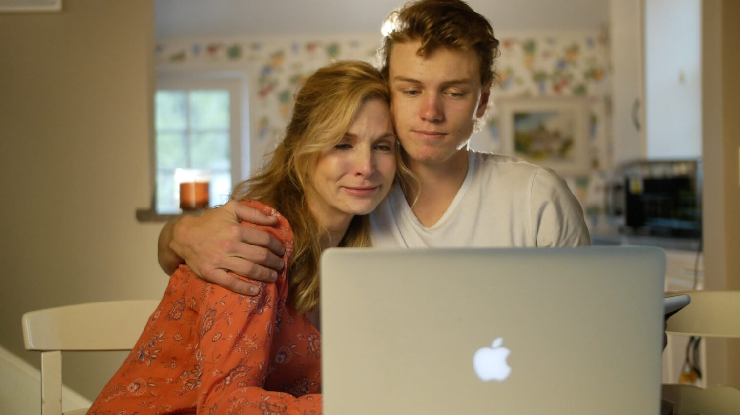 Evan and his mother, Kate, watch as the pics from sister Julia come in from New York